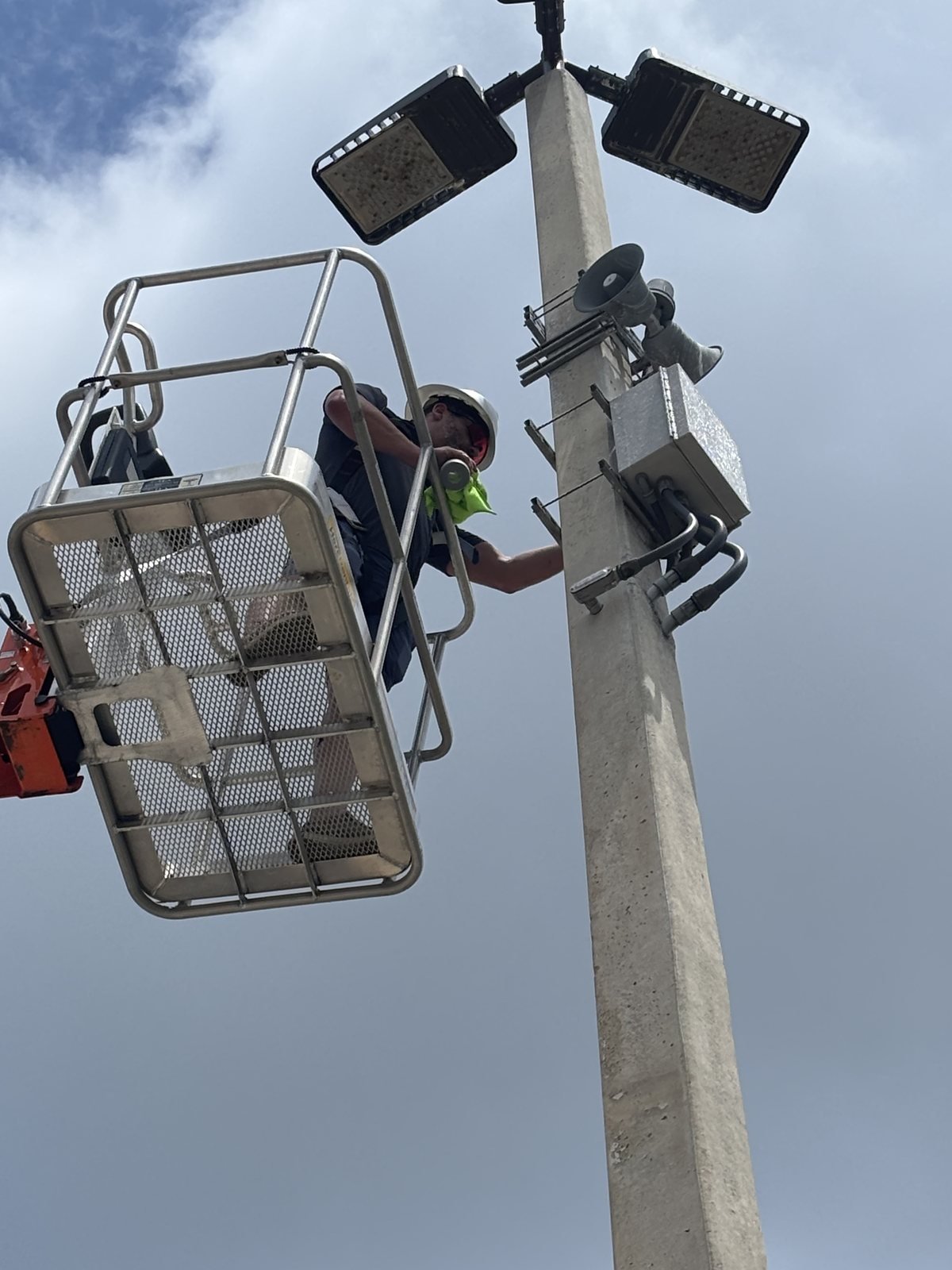 Working on a pole mounted camera and lighting head during a crime prevention through environmental design site assessment